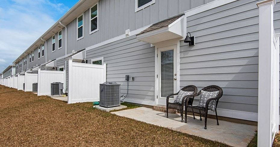 a patio with two chairs in front of a building