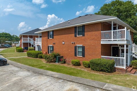 A red brick house with a white porch.