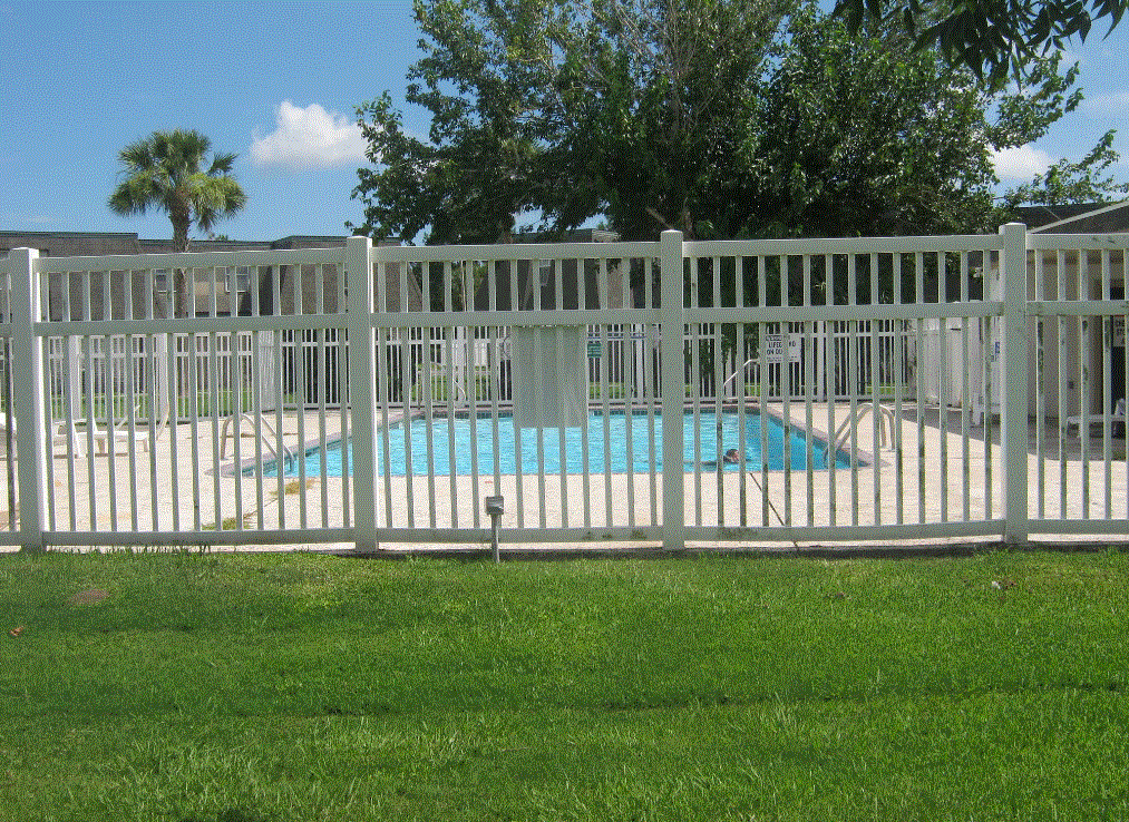 a white picket fence in front of a swimming pool