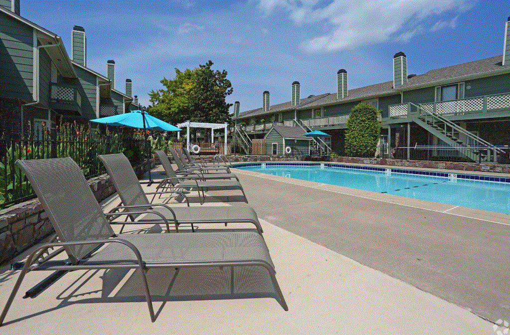 a swimming pool with chaise lounge chairs and umbrellas