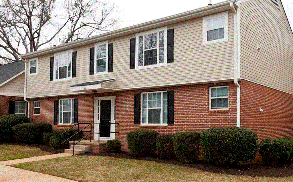 a brick house with black shutters and a black front door