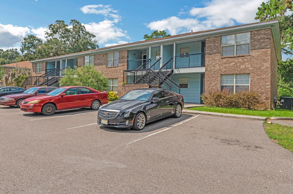 a car parked in a parking lot in front of an apartment building
