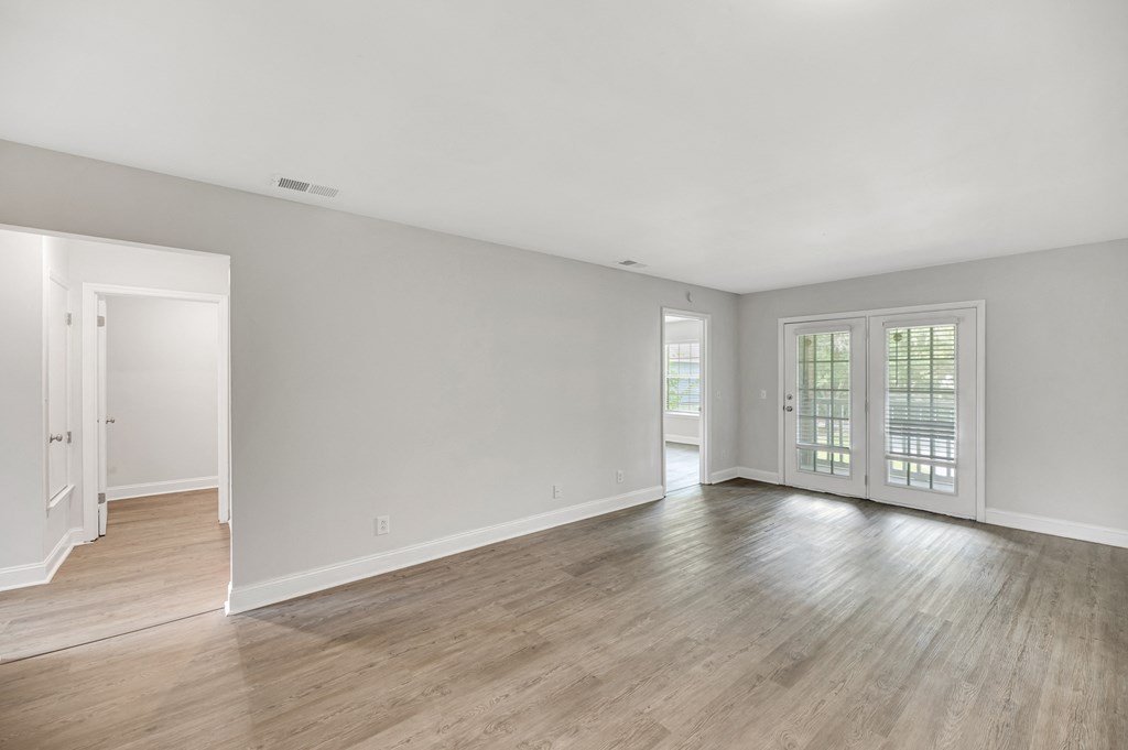 an empty living room with white walls and wood floors
