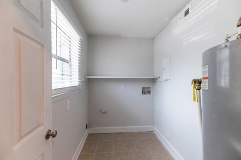 an empty kitchen with a refrigerator and a window
