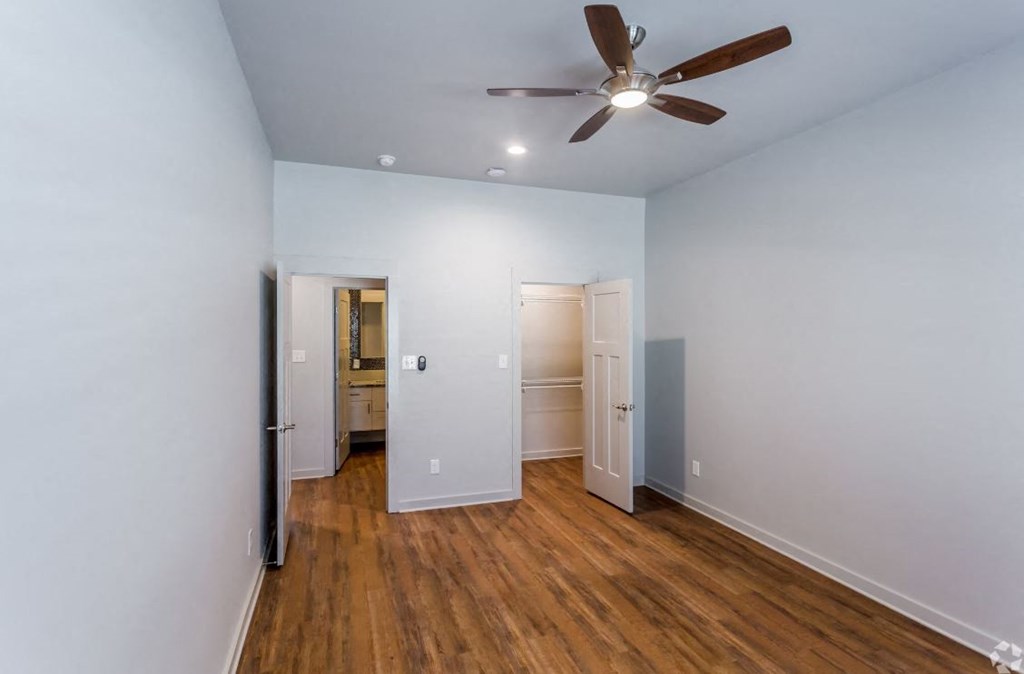 a bedroom with a ceiling fan and hardwood floors