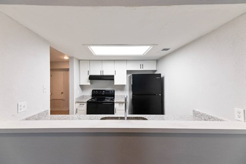A modern kitchen with a black refrigerator and stove.