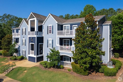 a large blue house with a yard and trees