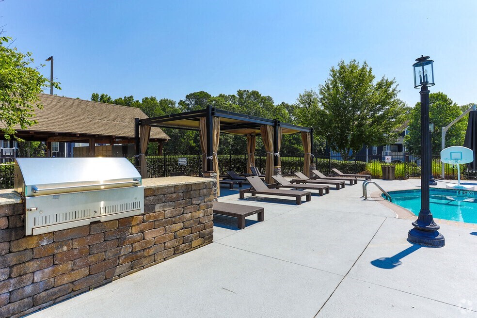 a swimming pool with chaise lounge chairs and a hot tub