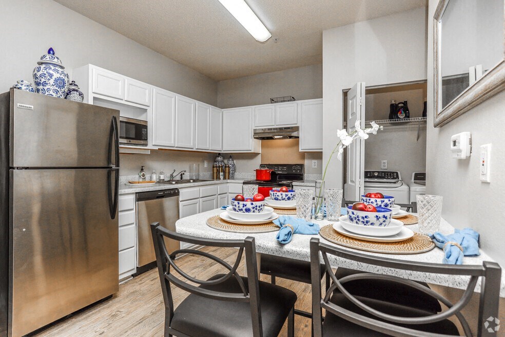 a kitchen with stainless steel appliances and a dining room table