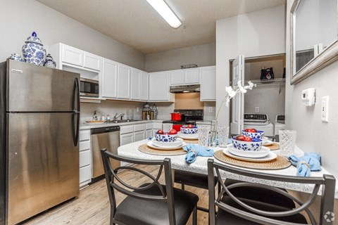 a kitchen with stainless steel appliances and a dining room table