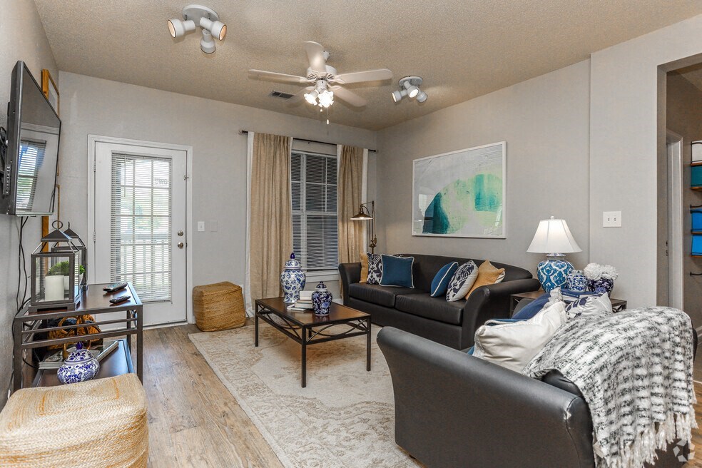 a living room with couches and a coffee table and a ceiling fan