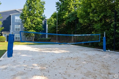 a tennis court with a blue net in front of a house