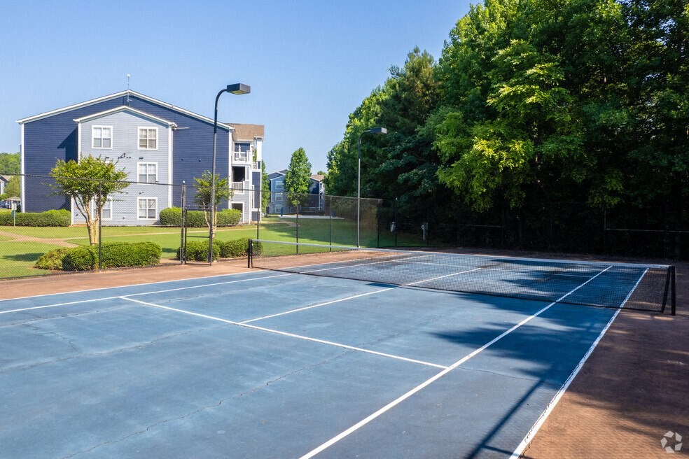a blue tennis court with a building in the background