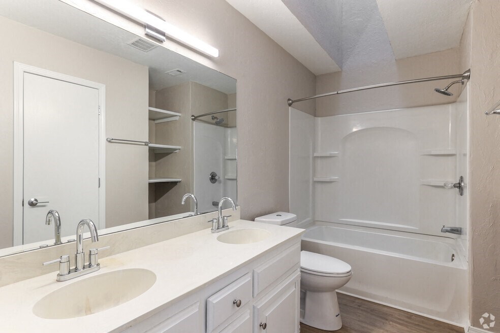 a bathroom with two sinks and a toilet and a shower