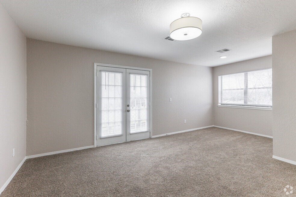 an empty living room with a white door and window