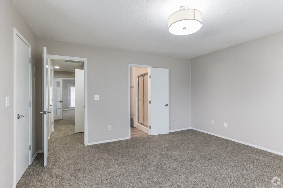 an empty living room with carpet and a door to a hallway