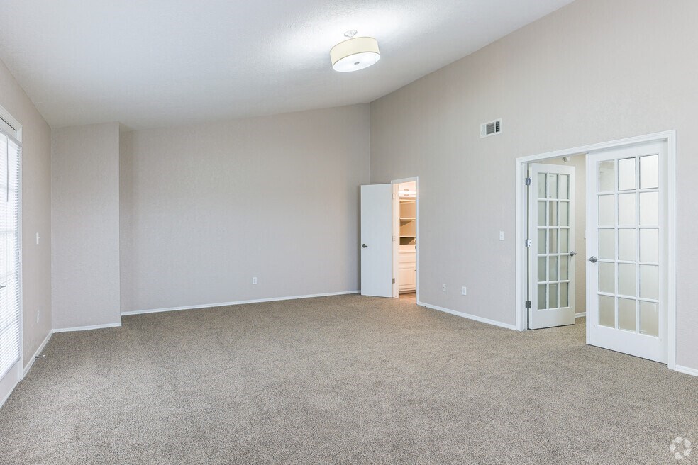 an empty living room with a door to a closet