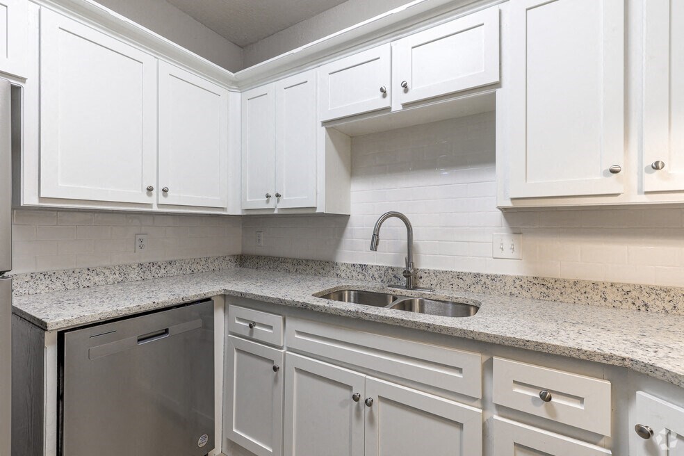 an empty kitchen with white cabinets and a sink