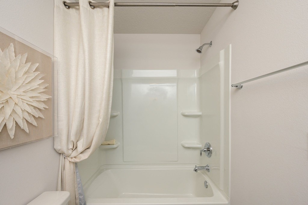a bathroom with a shower and a toilet and a shower curtain