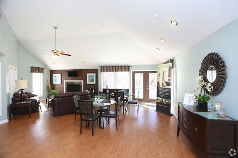 A spacious living room with a dark wood floor and furniture.