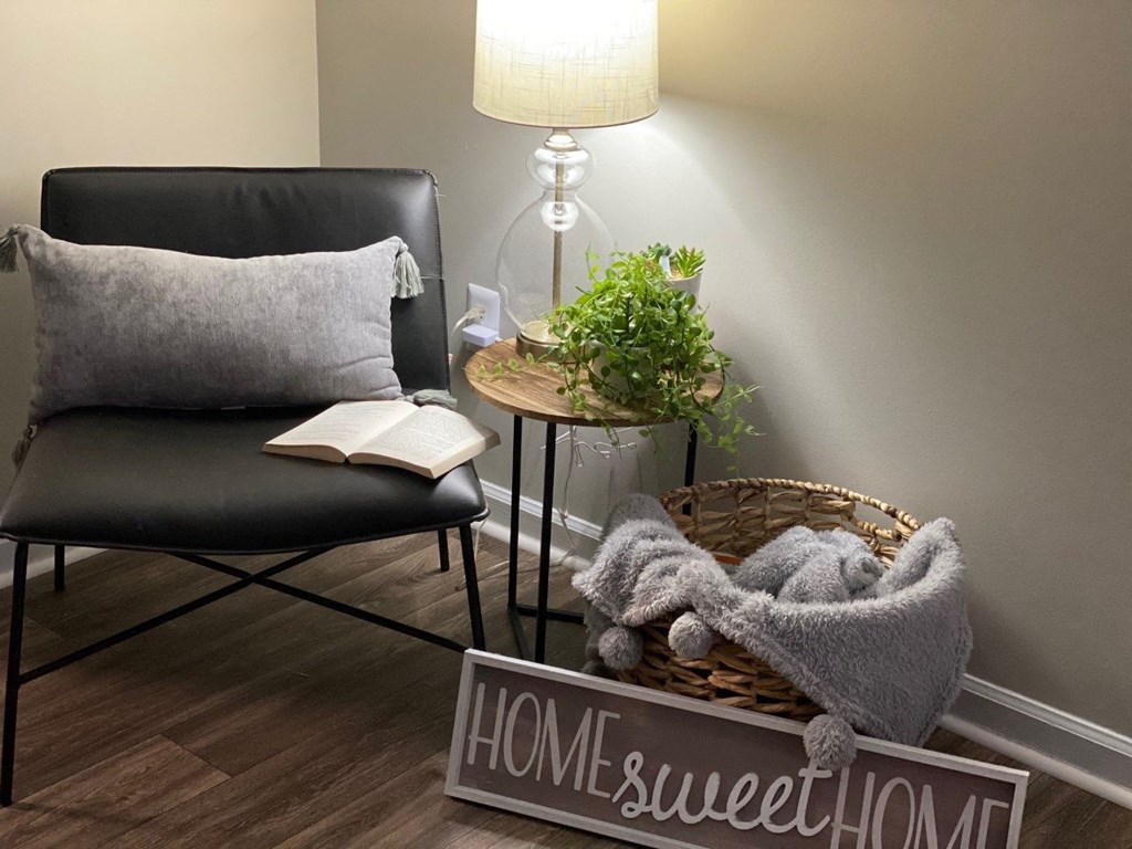 a living room with a chair and a basket with a book