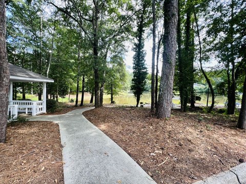 a walkway leading to a house with a lake in the background