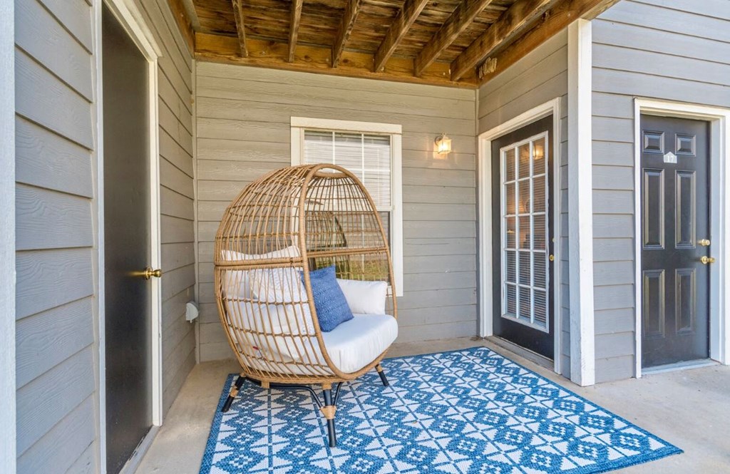 a hammock chair on the front porch of a house