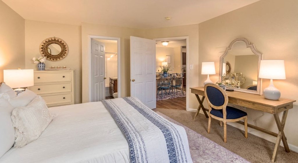 a bedroom with a bed and a desk with a mirror