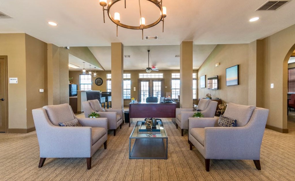 a lobby with chairs and tables and a chandelier