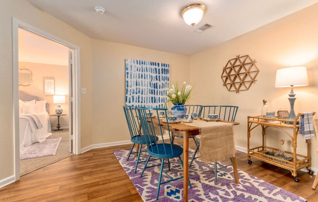 a dining room with a table and chairs and a bedroom with a bed