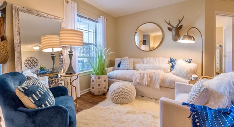 a living room with a couch and a chair and a mirror