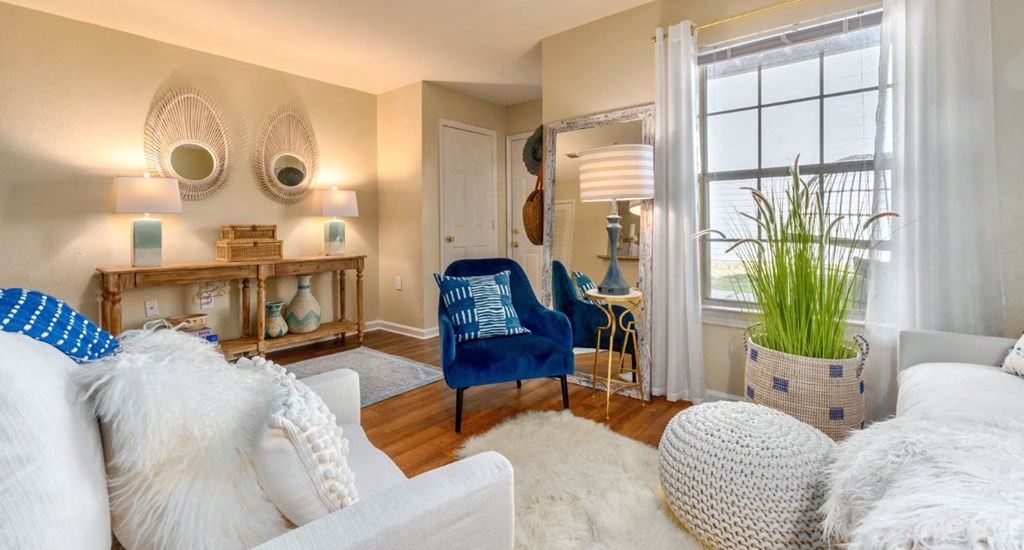 a living room with white furniture and a large window