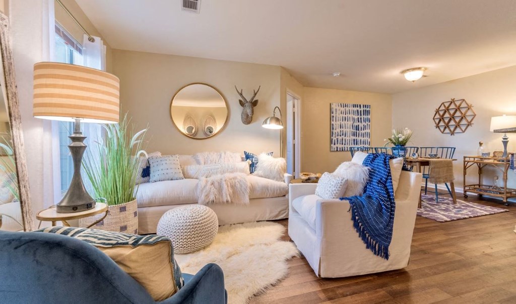 a living room with couches and a table and a mirror