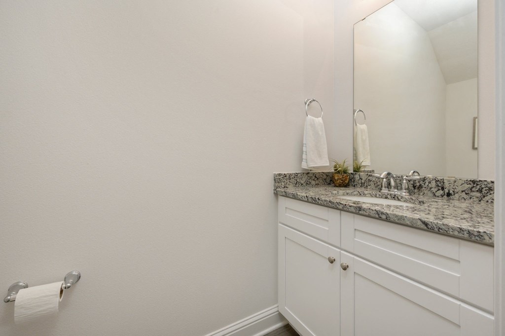 a bathroom with white cabinets and a sink and a mirror