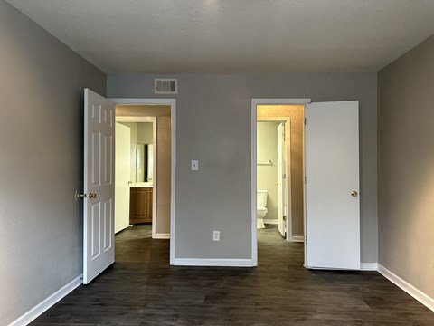 a living room with a door open to a hallway and a bathroom