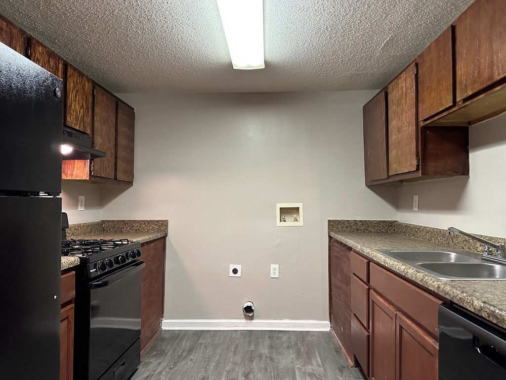 a kitchen with wooden cabinets and a stove and a sink