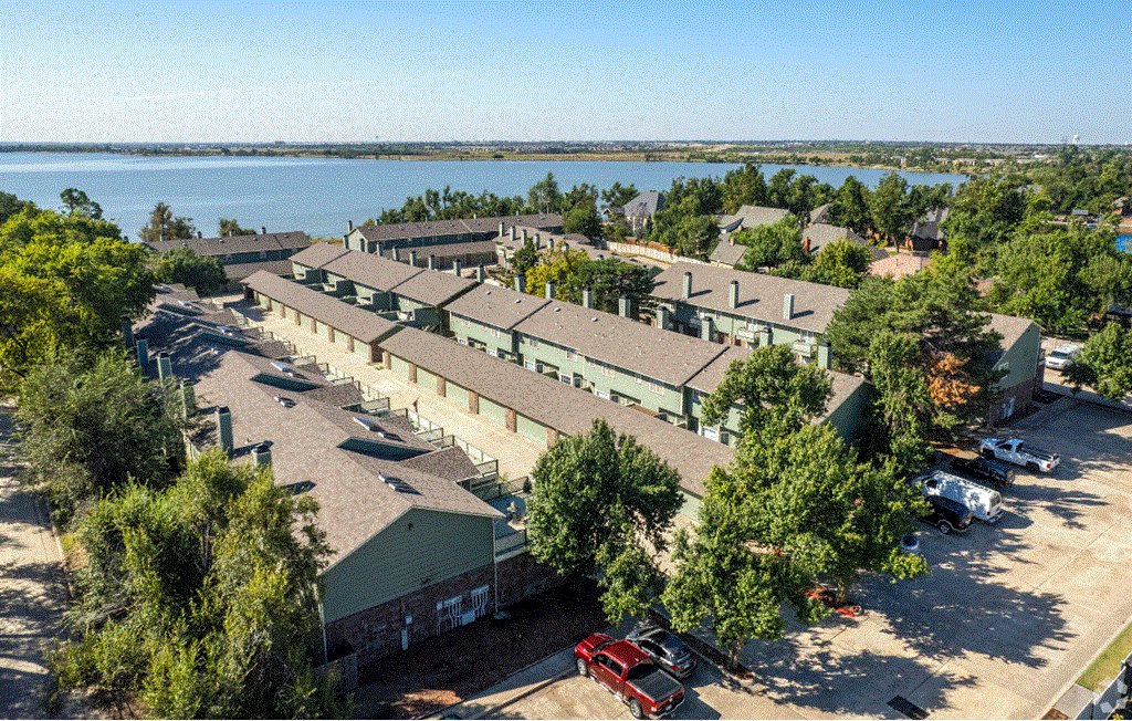 a view from above of a row of houses with a body of water in the background