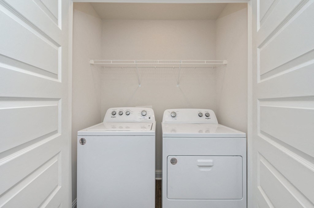 a washer and dryer in a laundry room with white doors