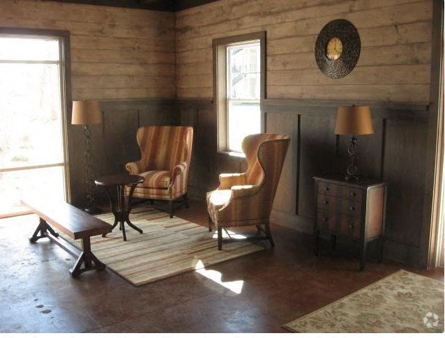 a living room with two chairs and a rug