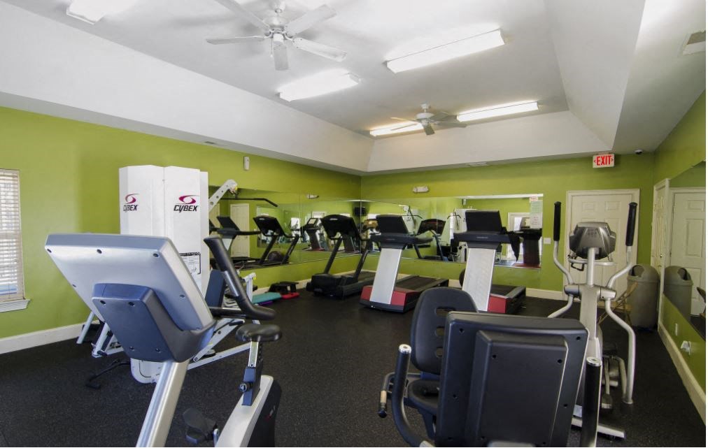 a gym with various cardio equipment and weights