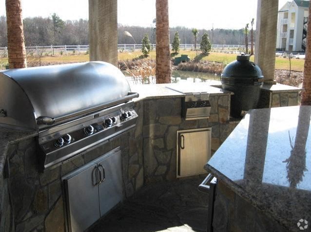 an outdoor kitchen with a grill and a table