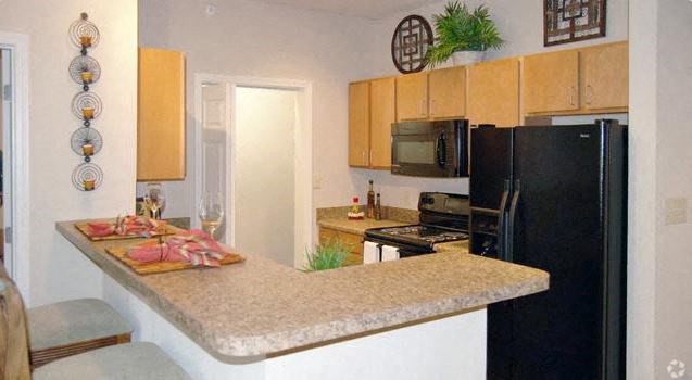 a kitchen with a granite counter top and a black refrigerator