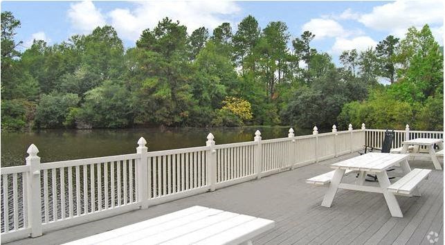 a deck with benches and tables overlooking a river