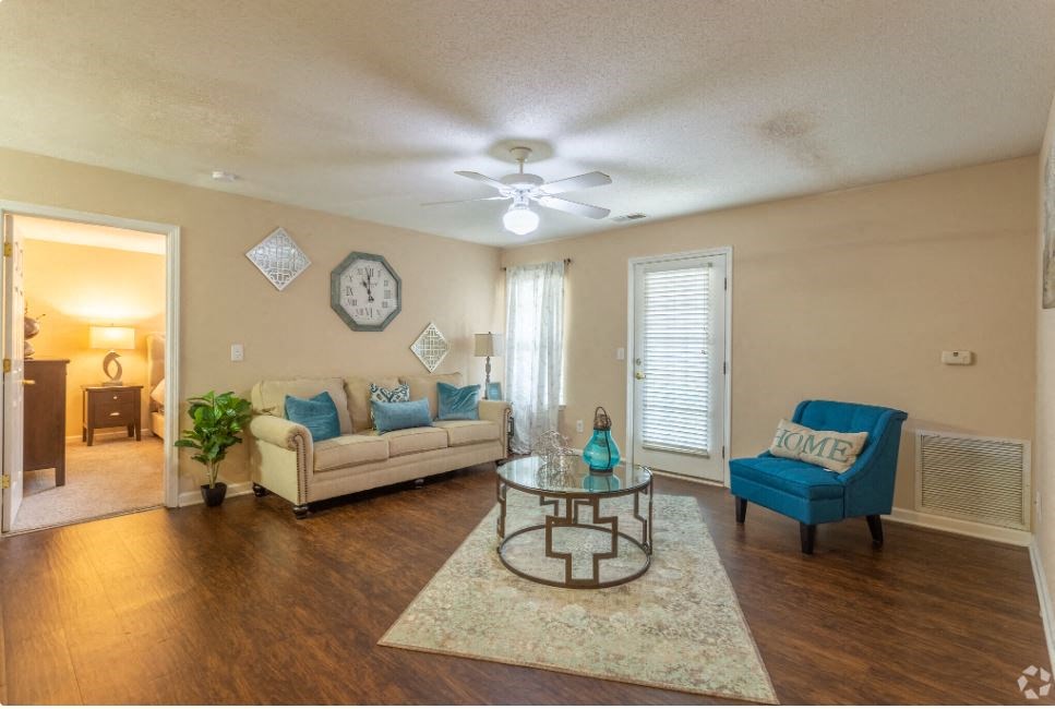 a living room with furniture and a ceiling fan