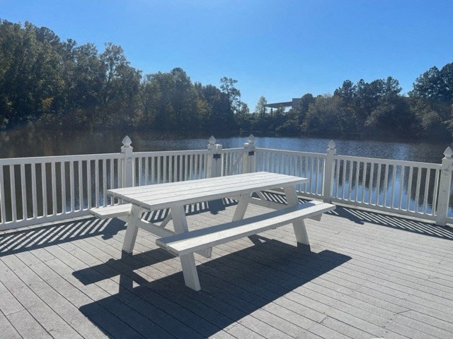 a picnic table on a deck overlooking a body of water