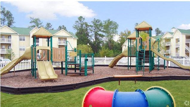 a childrens park with a playground and slides
