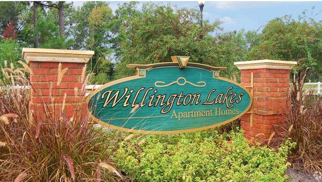 a sign in front of a brick fence