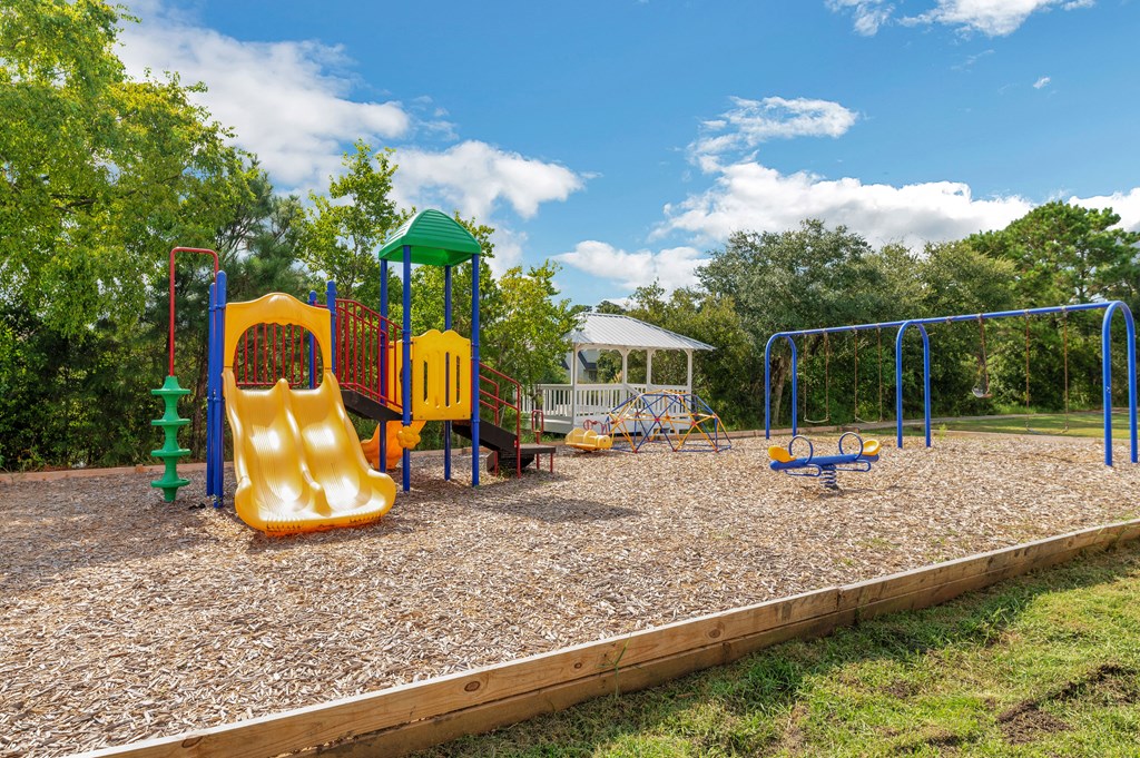 a playground with a swing set and slides at a park
