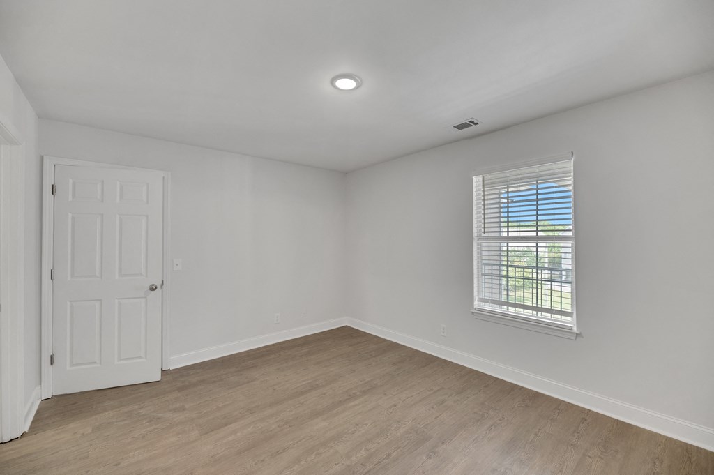 an empty living room with white walls and a window
