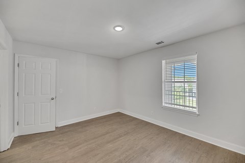 an empty living room with white walls and a window